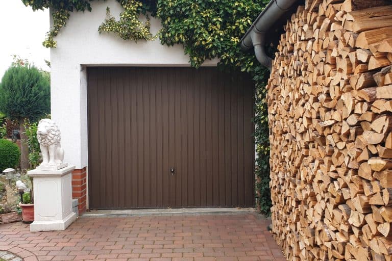 A view of a pile of firewood stacked in a garage prepared for winter, How To Store Firewood In Garage [And Is It A Good Idea?]