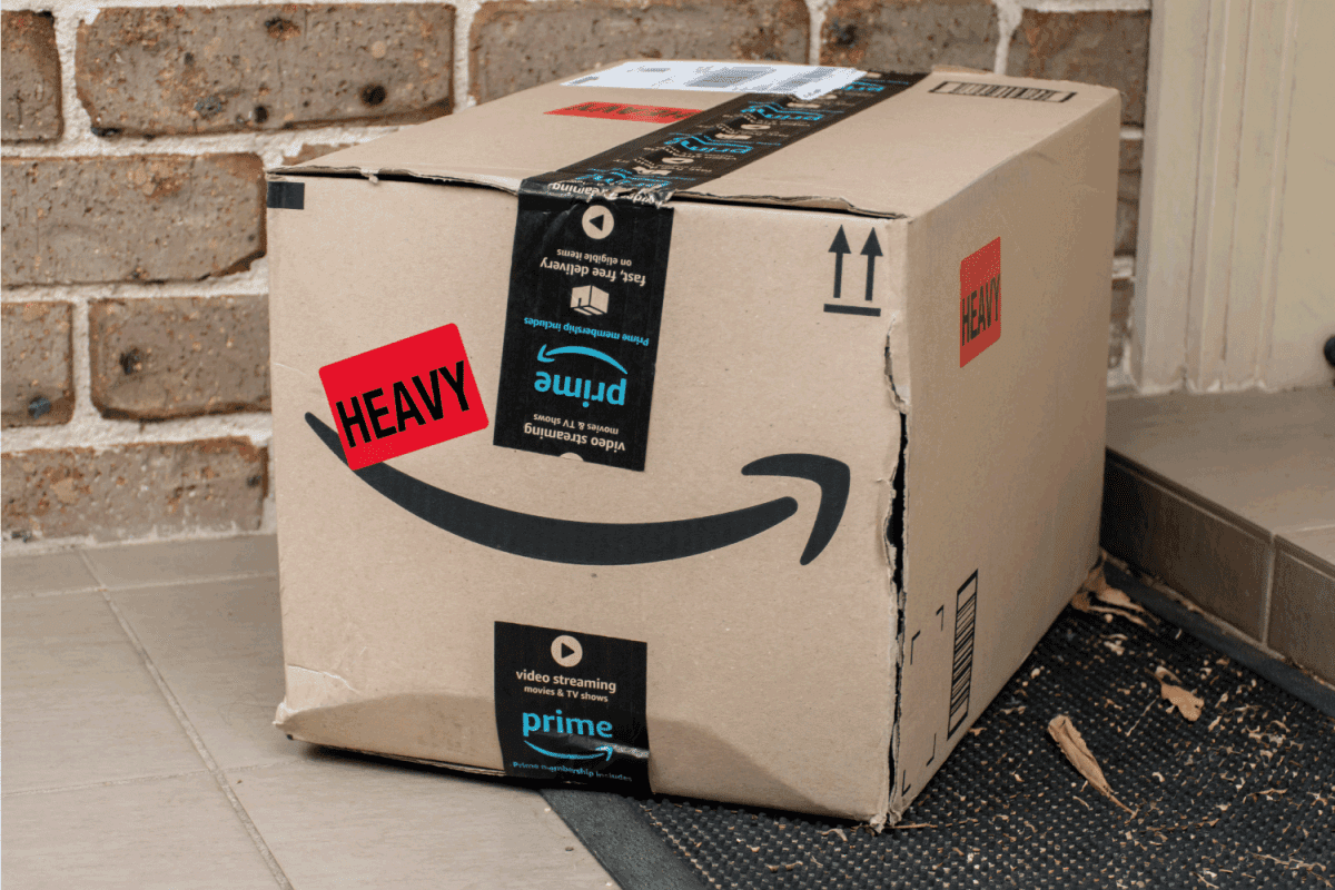 Amazon prime box delivered to a front door of residential building with brick work wall