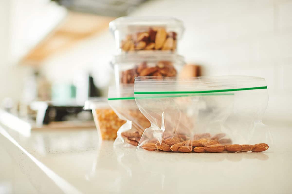 Assorted nuts in plastic containers on a counter in a bright modern kitchen