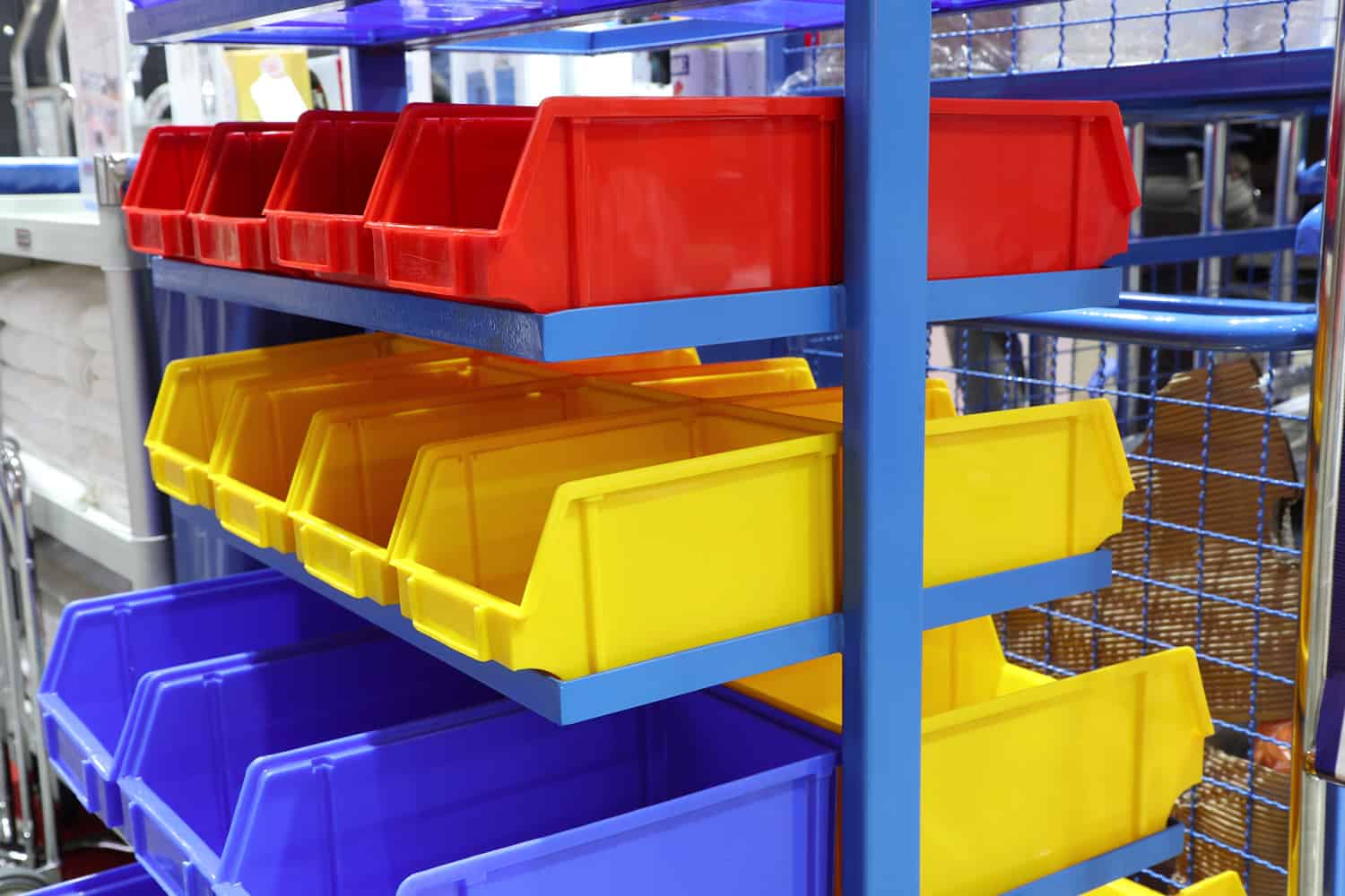 Colourful plastic bins at shelf for storage spare parts