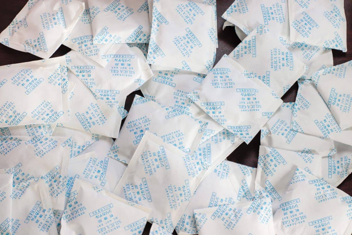 Natural Desiccant Silica gel bag on hand with white bokeh

