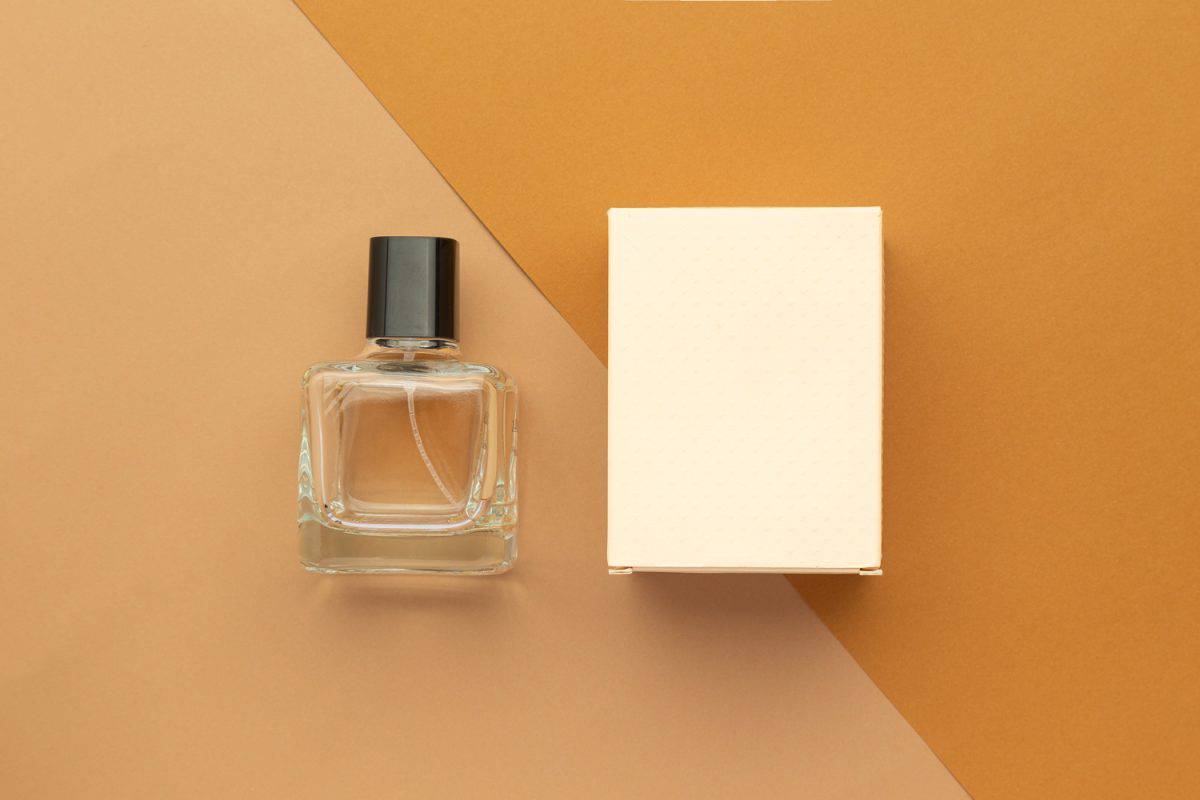 Perfume bottle and box mockup template on beige background.
