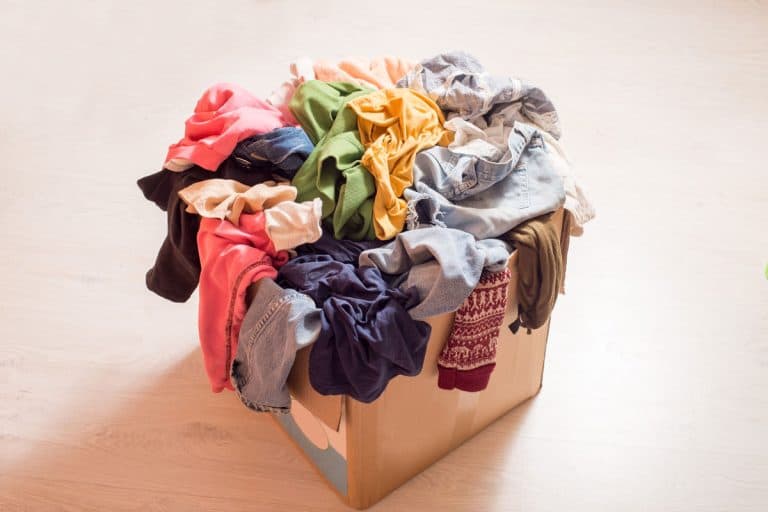 Pile of clothes in a large cardboard box, Can You Store Clothes In A Cardboard Box?
