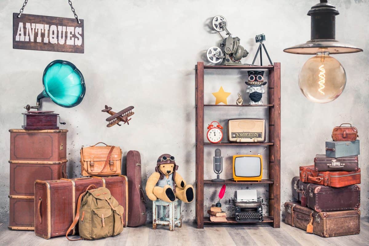 Vintage travel suitcases, backpack, old gramophone, TV, radio, mic, projector, clock, typewriter, quill, books, camera, Teddy Bear, toy plane, signboard, mask. Antiques collectibles