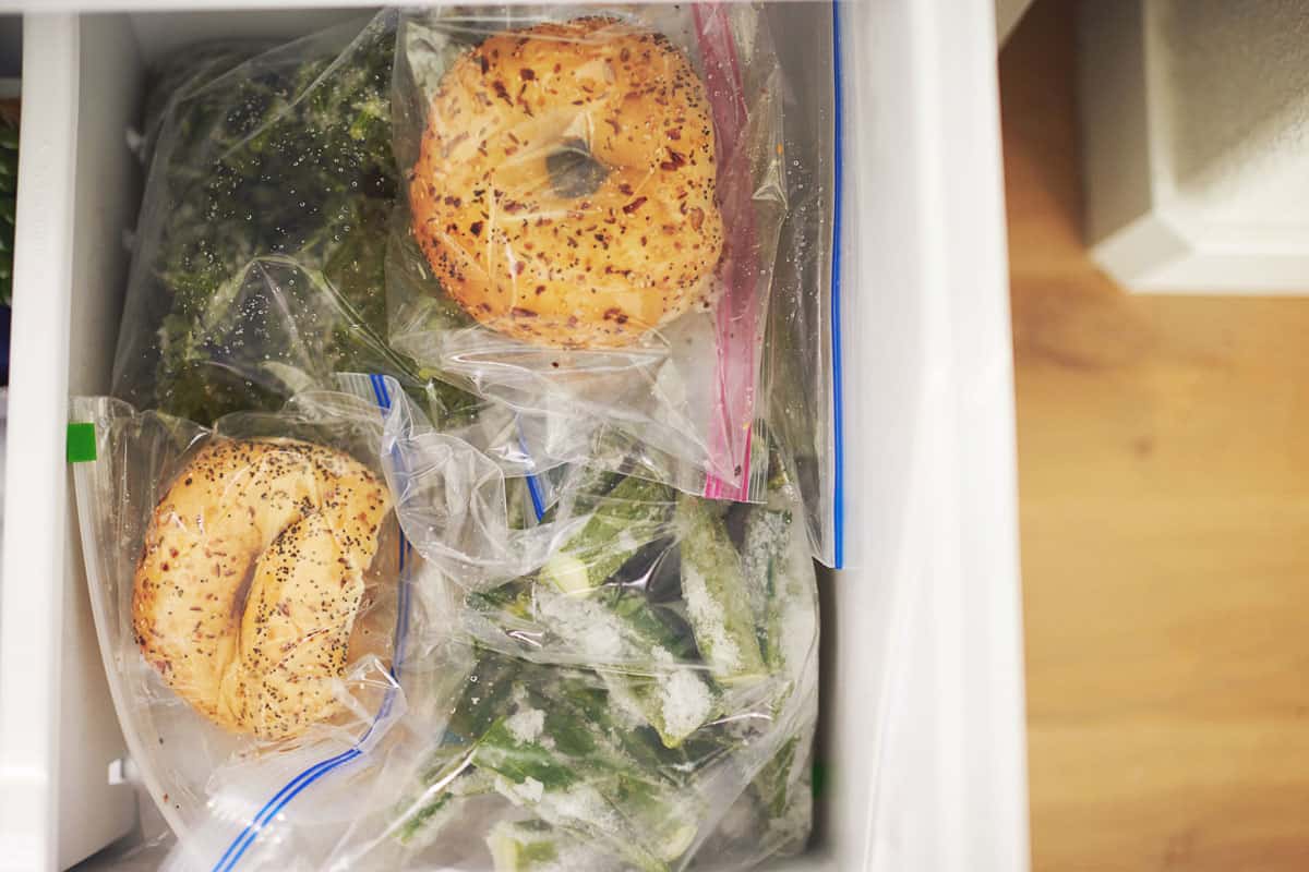 Vegetables and bagels in zippered plastic bags in a freezer