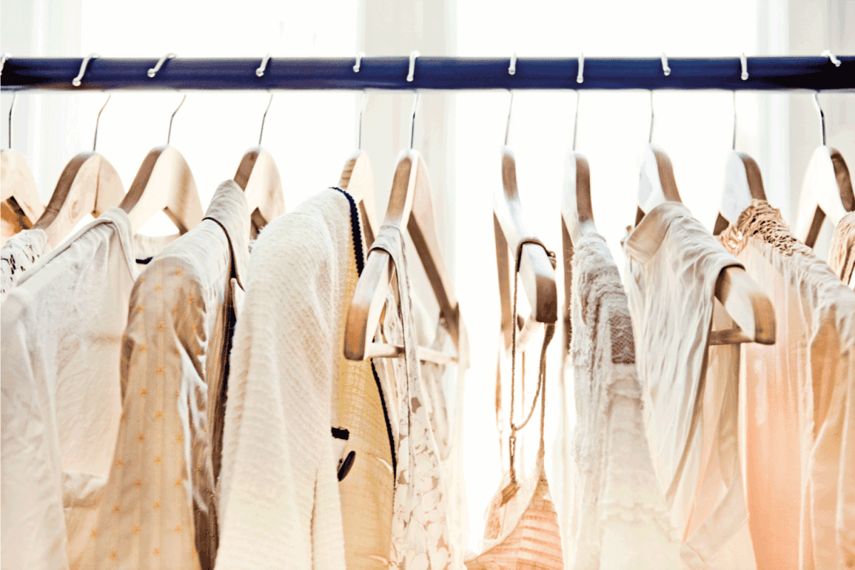light-colored clothing secured on wooden hangers is visible