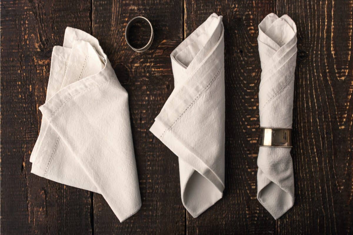 white napkins with vintage metal ring on the wooden table