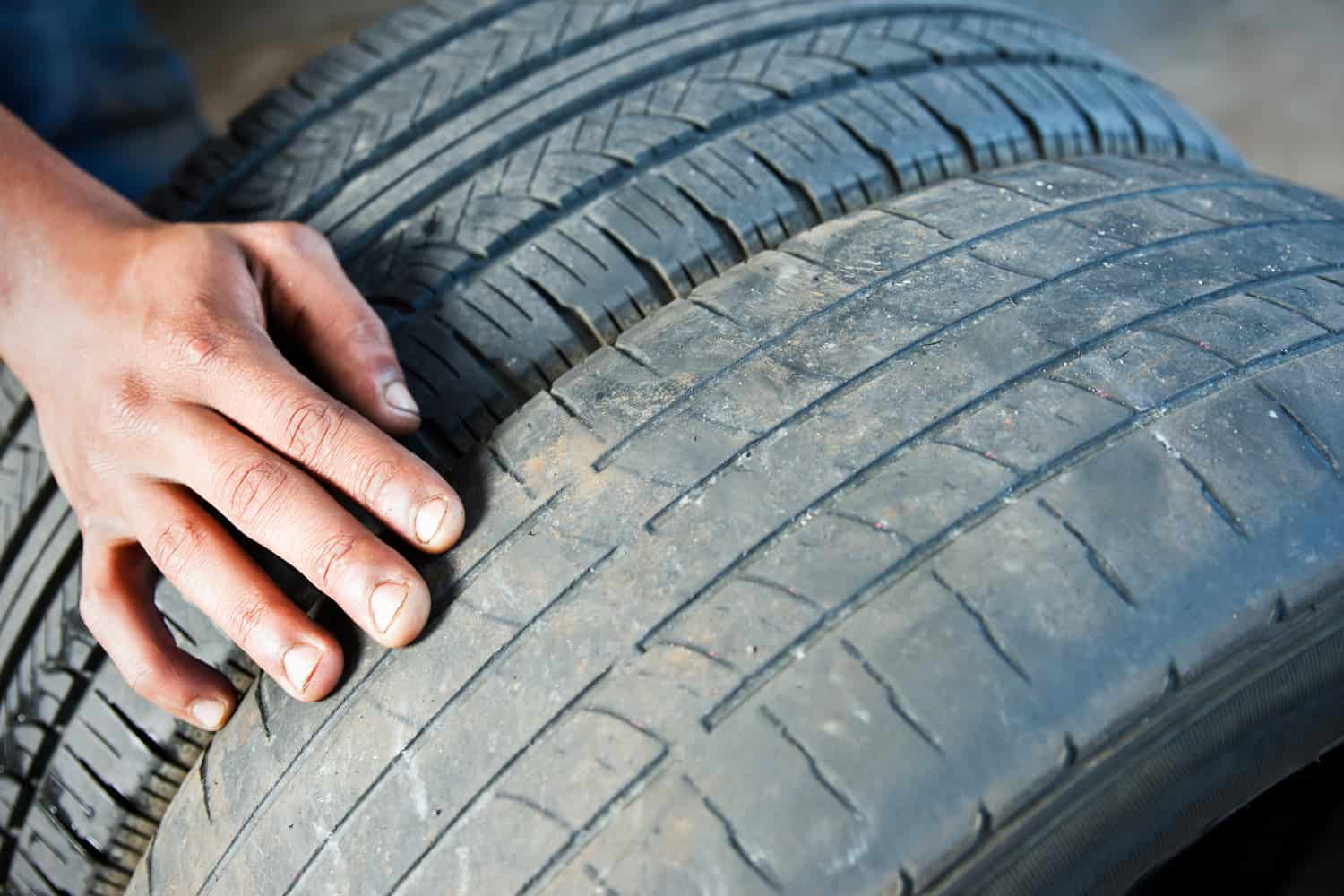 A photograph comparing a dangerously worn tire beside a newer tire with acceptable tread.