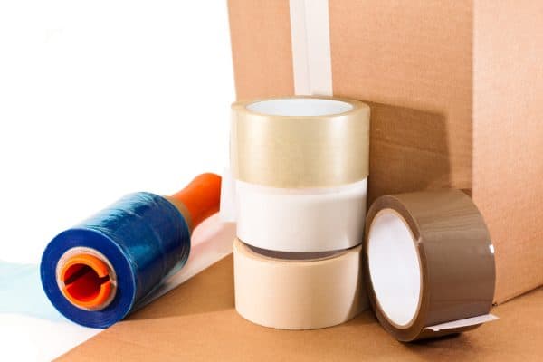 Cardboard for packaging, adhesive tape and nylon on white background - How Much Packing Tape Do I Need For A Move
