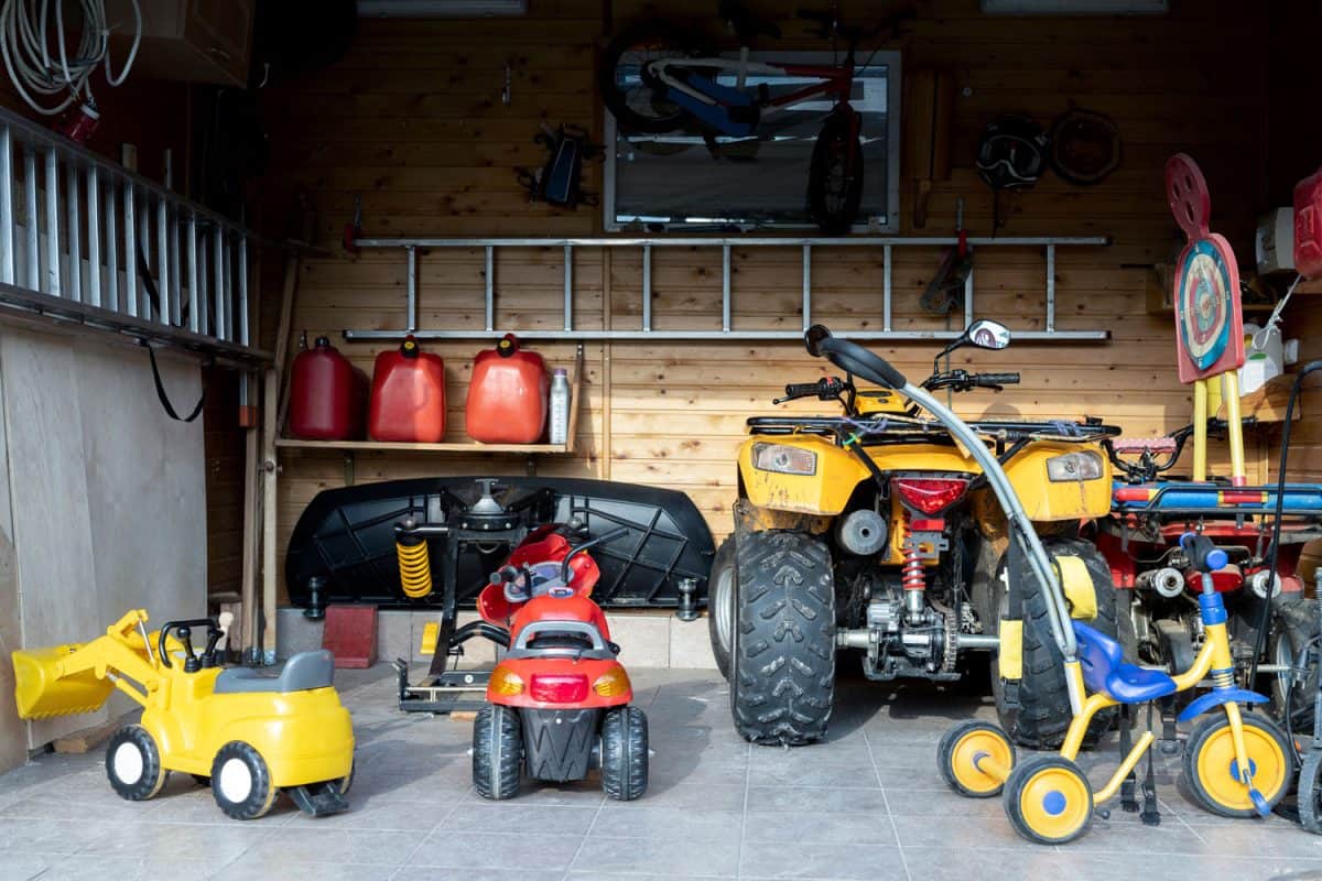 Interior of a garage filled with childrens toys and an ATV
