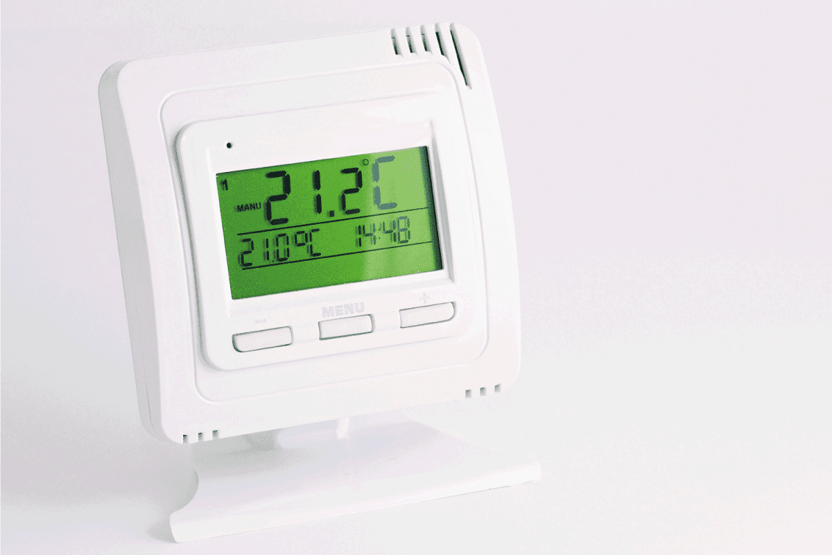 Remote home interior thermostat controller over white background.