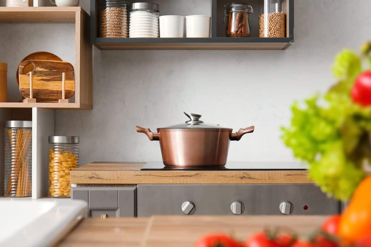 Shiny cooking pot on stove in modern kitchen
