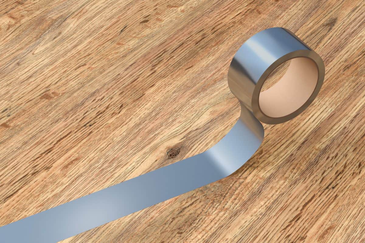 Silver duct tape roll on wooden background.