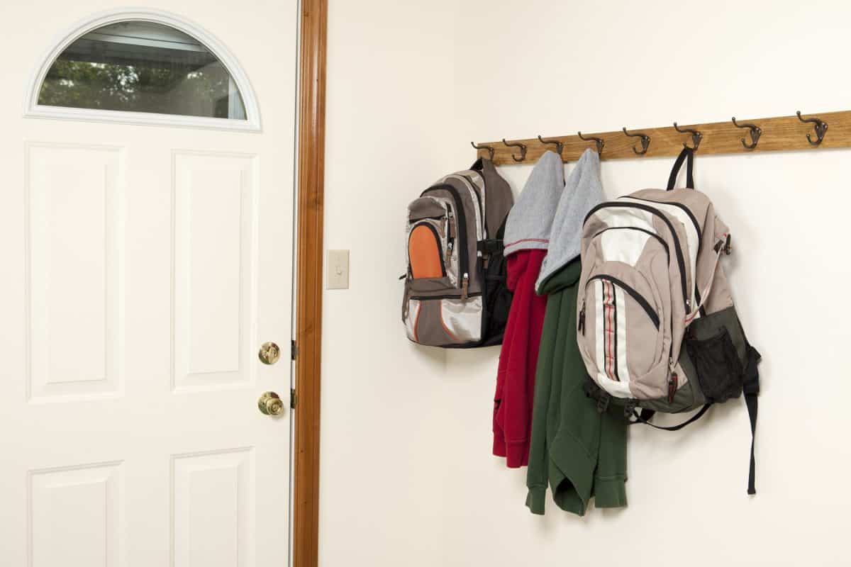 Two backpacks and jackets hanging on a wall rack by the back door.Please also see:

