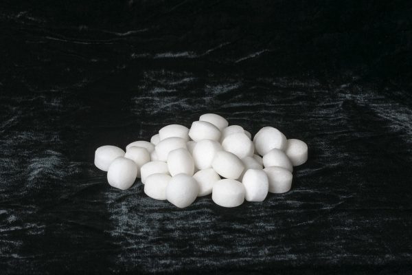White naphthalene balls on black velvet, 7 Mothball Alternatives For Clothes Storage