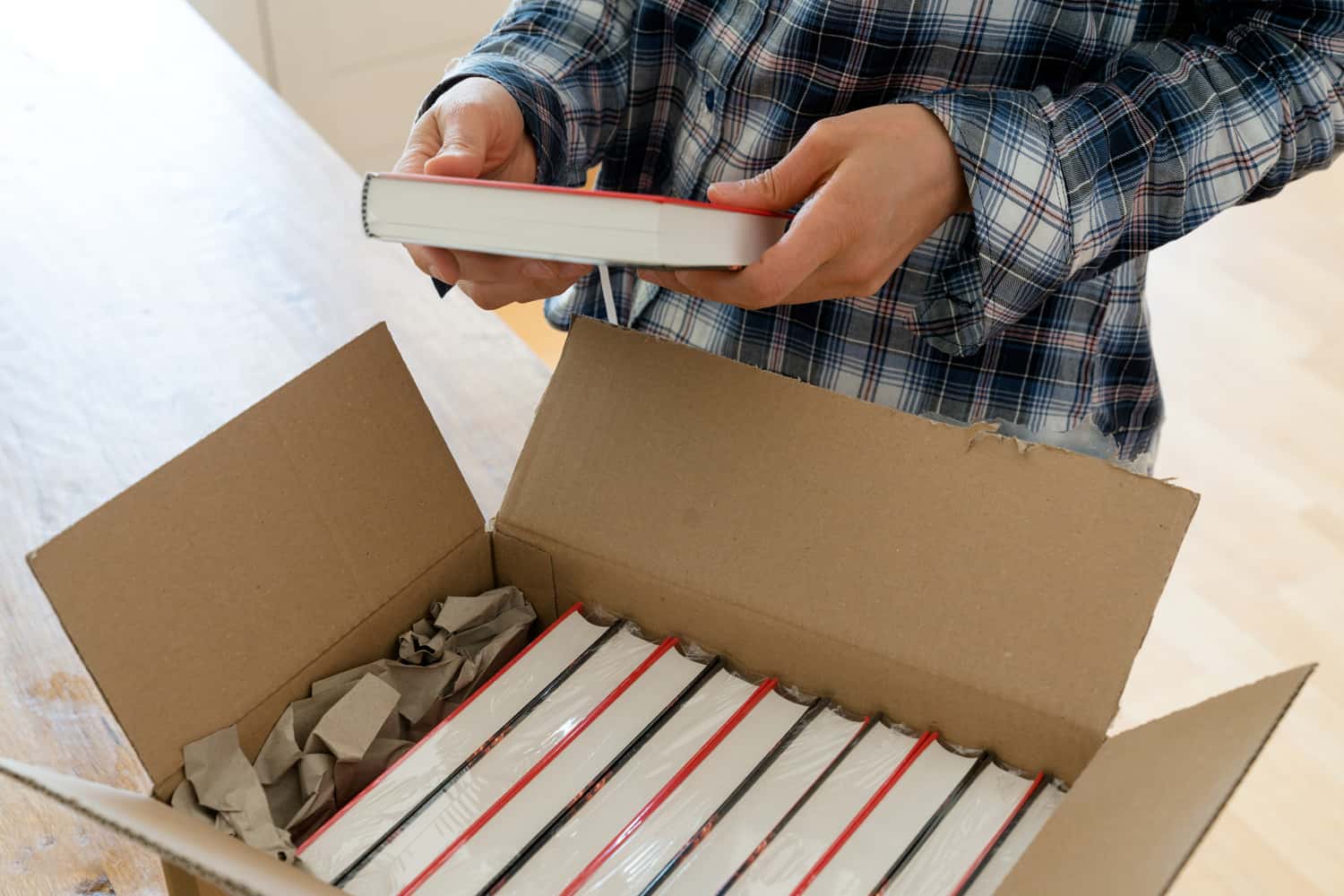 author opens package with samples of her new book and checks the hardcover edition carefully