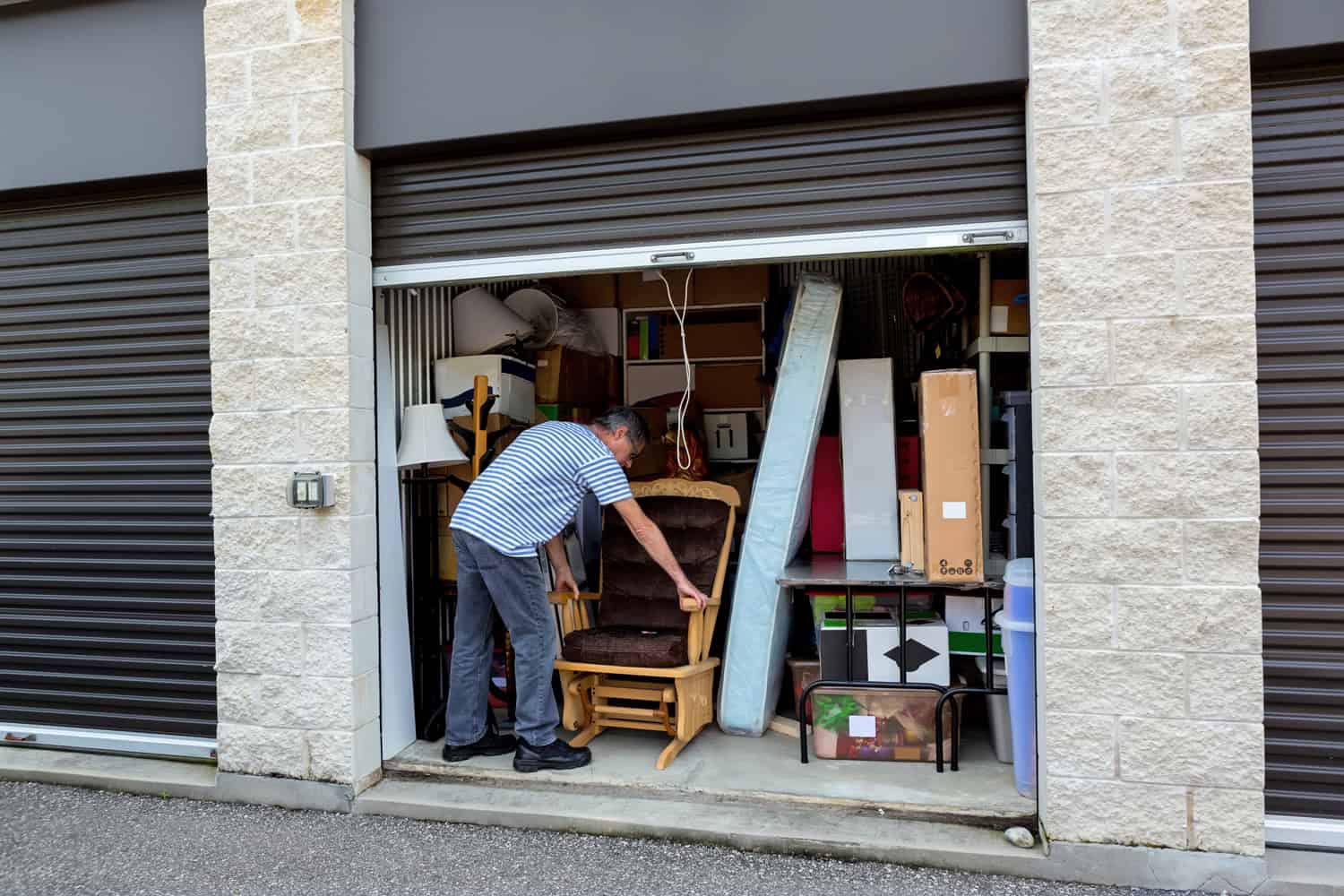 man holding a lock in front of a storage warehouse holding the contents of his home until he finds another place to live